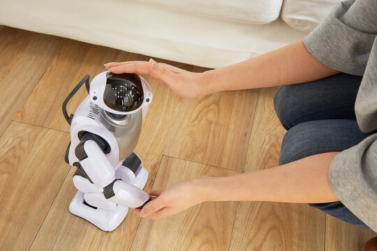 女性に頭を撫でられているロボット