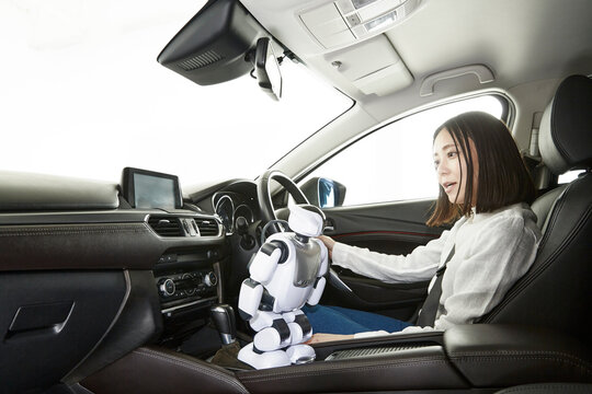 ロボットを使って自動運転車を操作する女性