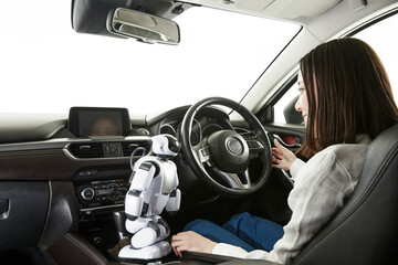 ロボットを使って自動運転車を操作する女性