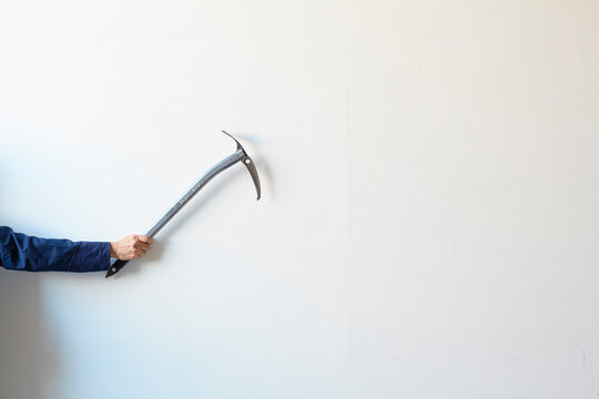 白い壁の前でピッケルを構える人