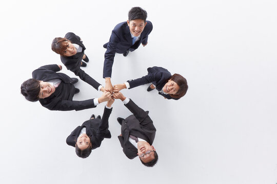 手を合わせ上を見上げる6人の新入社員