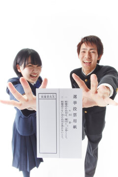 投票用紙に手を伸ばす学生