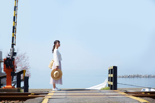 踏切で立ち止まって景色を見渡す女性 ,日本,大阪府,泉南市周辺