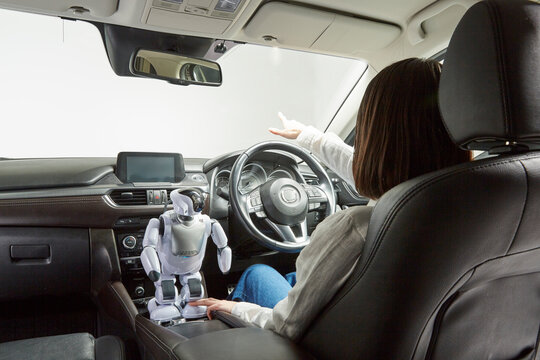 ロボットを使って自動運転車を操作する女性