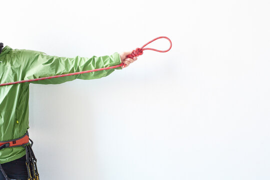 白い壁の前で結んだロープ持って引っ張る登山者