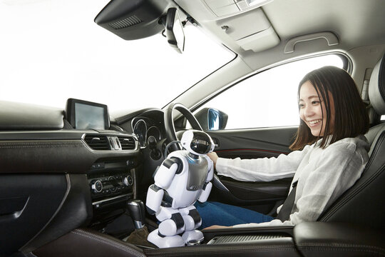 ロボットを使って自動運転車を操作する女性