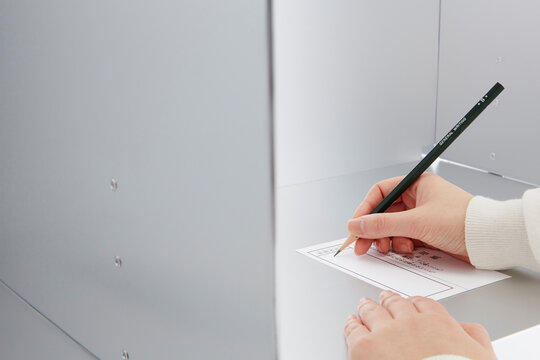 投票記載台を使用している女性の手元