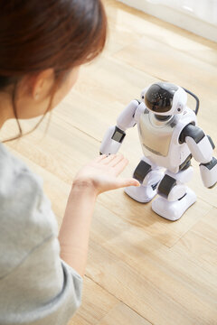 女性に手を差し出されているロボット