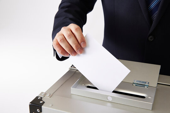 投票しているスーツを着た男性の手