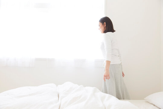 ベッドサイドをを歩く女性