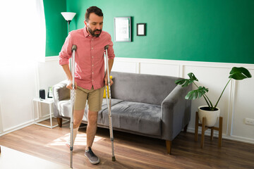 Fototapeta na wymiar Injured man walking with crutches
