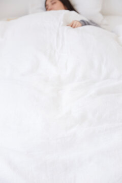 ベッドで寝る女性