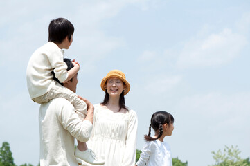 公園で息子を肩車して指差しする父とその家族4人