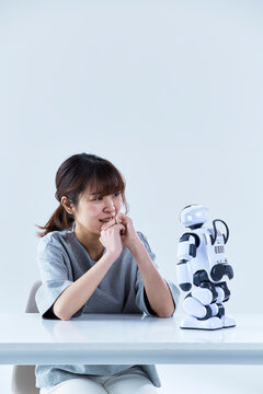 ミニロボットとおしゃべりする女性