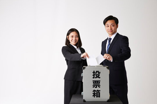 投票しているスーツを着た男性と女性