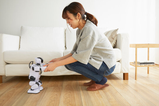 ロボットの両手を掴む女性