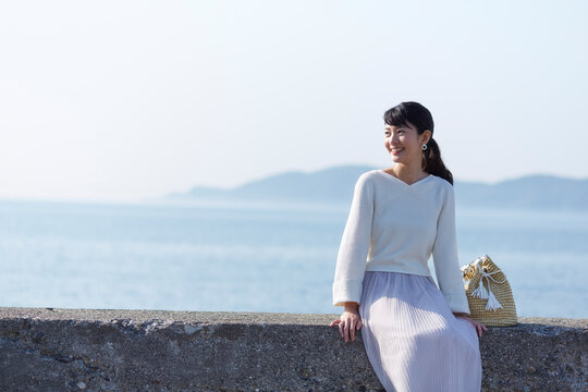 堤防に腰掛けている女性 ,日本,和歌山県,和歌山市,加太周辺