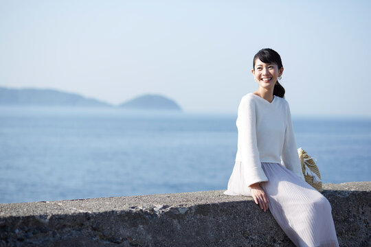 堤防に腰掛けている女性 ,日本,和歌山県,和歌山市,加太周辺