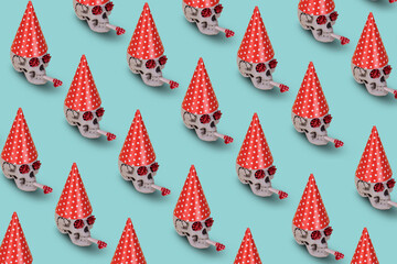 Pattern of human skull  with a red birthday cap and whistle on a blue background. Minimal holiday...
