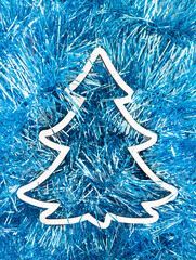 Christmas tree white frame on sparkling tinsel decoration in icy blue and silver colour. Creative copy space. Winter background. New Year or Christmas concept. Flat layout.