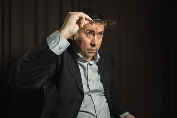 a man in a business suit raised his glasses and looked surprised