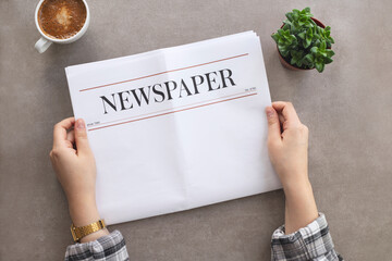 Woman reading morning newspaper at table