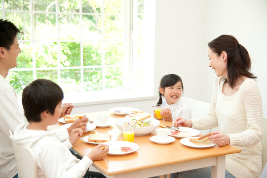 パンの朝食を食べる四人家族