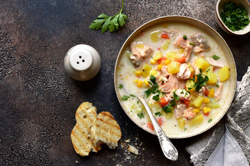 Chowder - thick potato soup with trout ( salmon ) and cream in a white bowl . Top view with copy space.