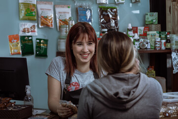Clienta se acerca al mostrador donde la cajera le muestra los productos y los precios