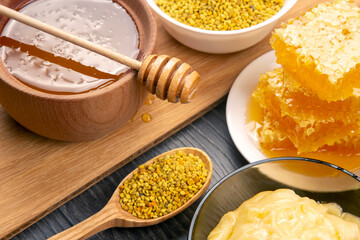 Fresh flower honey of different varieties, pollen and honeycomb with spoons on a wooden background. Organic Vitamin Health Food
