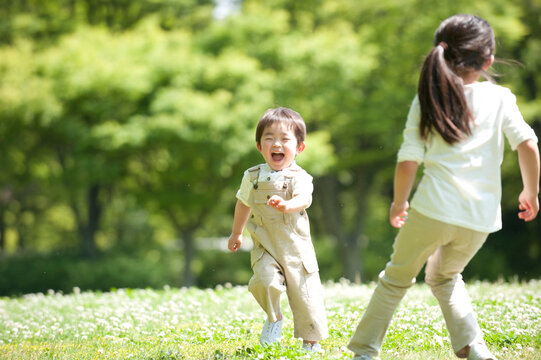 芝生の公園で遊ぶ子供男女