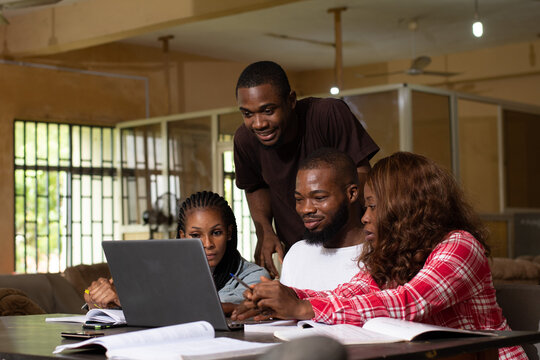 group of black students studying together, using a laptop to discuss their work