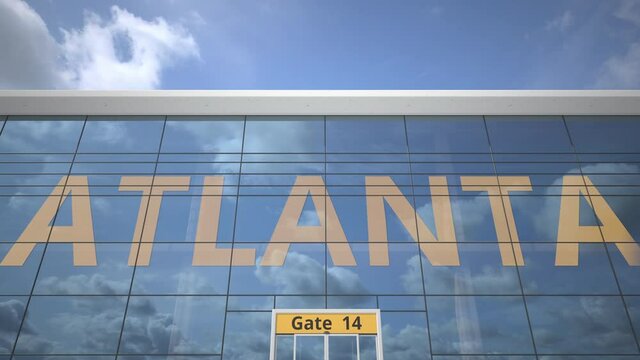 Airliner reflecting in the windows of airport terminal with ATLANTA text