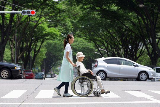 横断歩道を渡る介護士とシニア女性