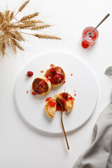 top view of plate with cheese pancake syrniki or cheesecakes with jum on white background