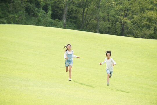 公園を走る子供男女