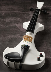 Violín eléctrico blanco sobre fondo oscuro