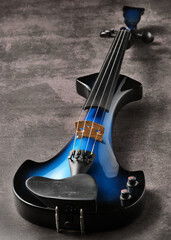 Violín eléctrico azul sobre fondo oscuro
