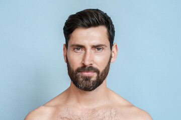 Closeup portrait of smiling half naked man looking at camera isolated over blue