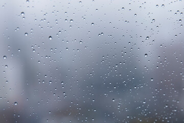 Water droplets in a close up on a high office building with city landscape in the background