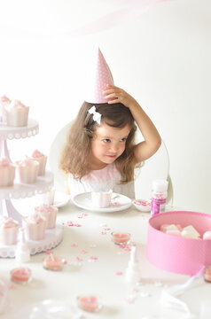 ピンクテーマのパーティで三角帽子を被るハーフの女の子
