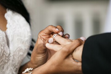 Obraz na płótnie Canvas Bride putting on wedding ring on Groom's finger