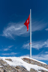 The flag of Switzerland on a flagpole in Diablerets glacier at 3000 meters above sea level in Switzerland