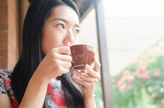 コーヒーを飲む黒髪の女性
