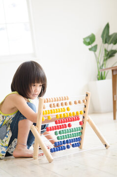100玉そろばんで遊んでいる女の子