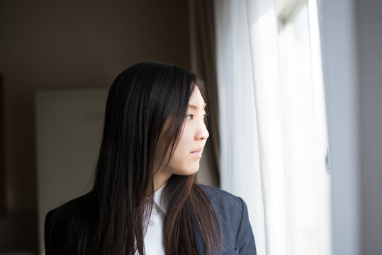 窓の外を眺めている女子高校生