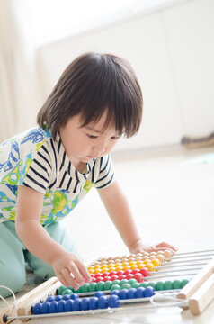 100玉そろばんで遊んでいる男の子