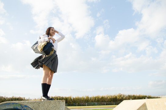 立って遠くを見ている女子学生