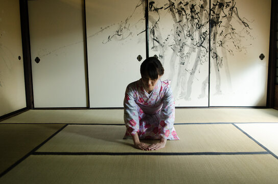 畳の上でお辞儀をしている着物姿の女性