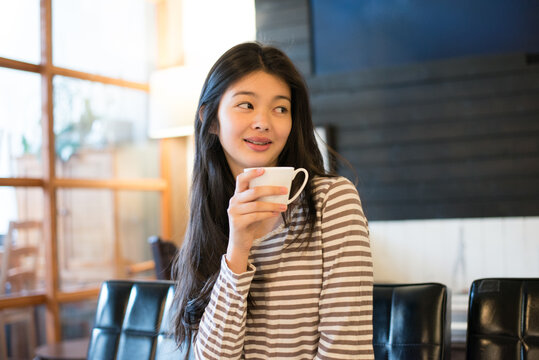 カフェでカップを持っている女性